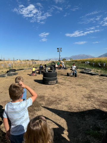 Students riding on trikes at the pumpkin patch.