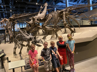 Students in front of dinosaur exhibit.