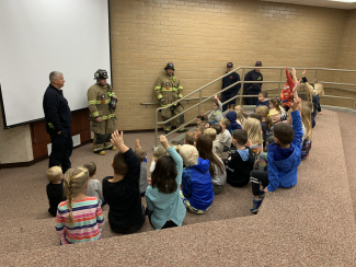 Students listening to fireman presentation.