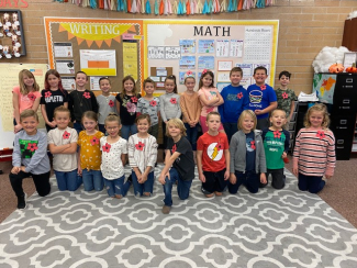Second grade class wearing red paper poppies.
