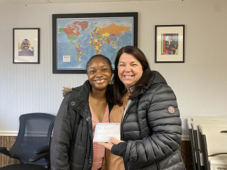 Ms. Paynter presenting a check to a woman at Utah Valley Refugees.