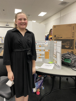 Student in front of science fair project.