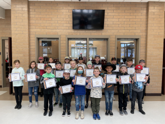 Students holding Student of the Month certificates.