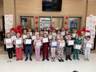 Students of the Month holding their certificates.