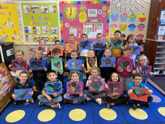 First graders showing off their completed artwork.