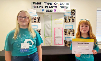 McKinely Rothlisberger and Ellie Earl posing with their project and certificate.