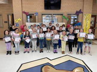 Students holding their student of the month certificates.