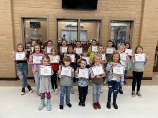 Students holding their Student of the Month certificate.