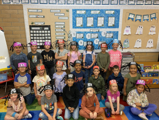 Class picture of students wearing spider headbands.