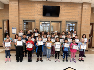 Students holding up their Student of the Month certificates.