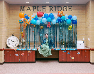 Mrs. Matis posing in front of an ocean theme office display.