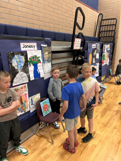 A student talking to other students about their artwork.